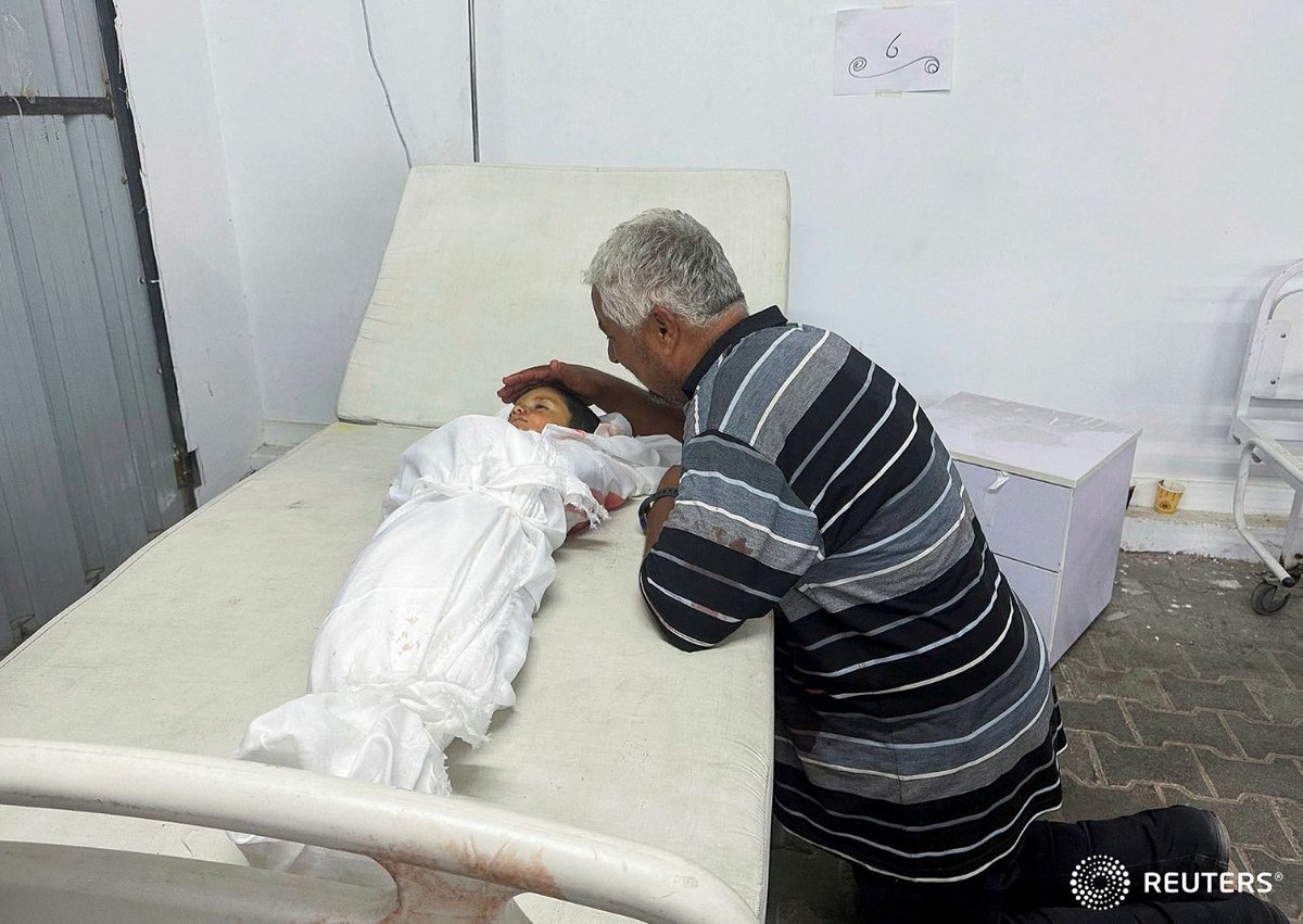 A man reacts next to the body of a Palestinian child killed in an Israeli strike on an area designated for displaced people, in Rafah in the southern Gaza Strip, May 26, 2024. REUTERS/Moaz Al Hams