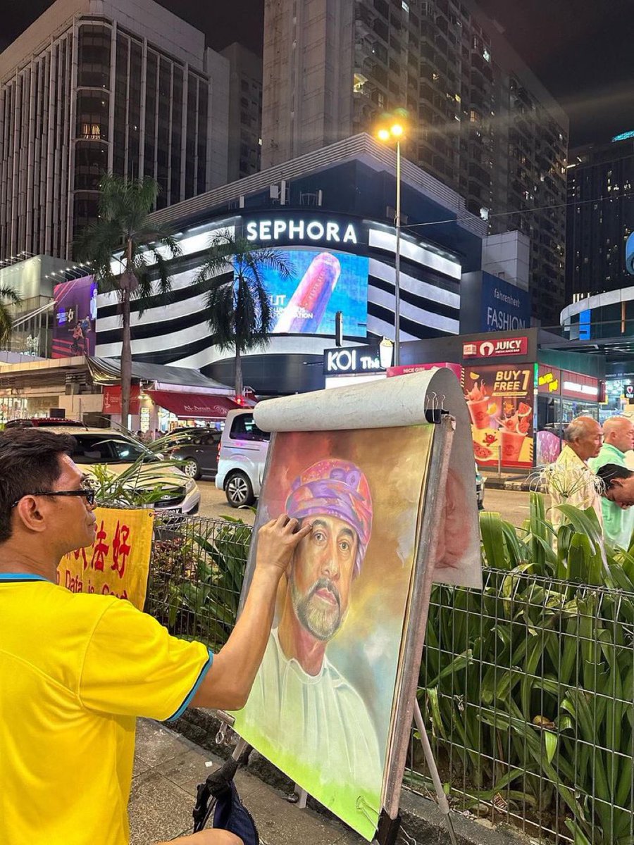 رسام ماليزي يقوم برسم صورة للسلطان #هيثم_بن_طارق حفظه الله ورعاه في أحد شوارع العاصمة #كوالالمبور. #هيثم_العهد_السعيد
