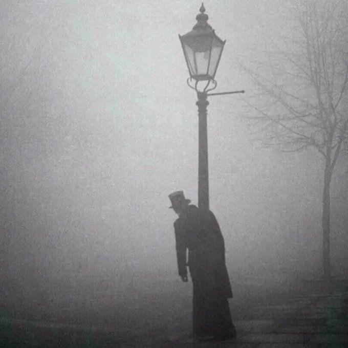 A drunk man in a top hat clings to a lamp-post in London, 1934 Photo is by Bill Brandt.