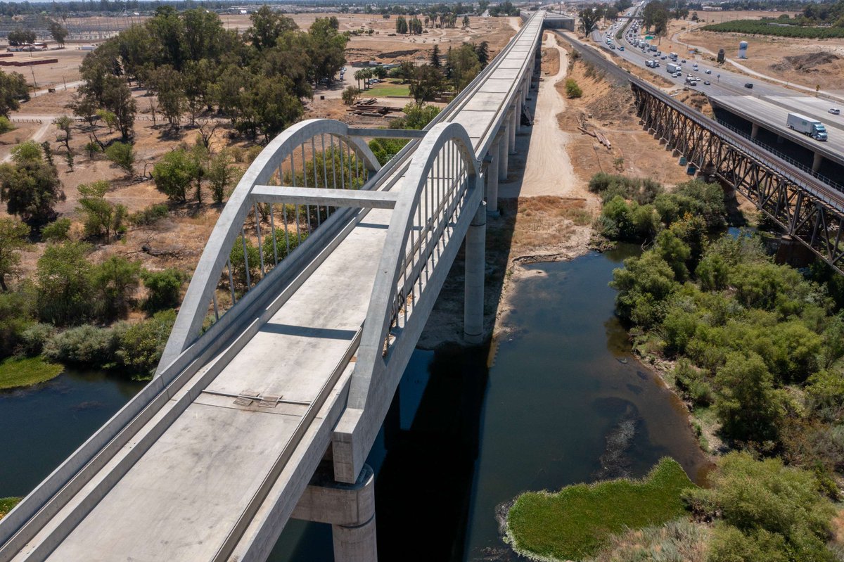 CaHSRA's tweet photo. The San Joaquin River Viaduct straddles the Madera &amp; Fresno County lines &amp; will take high-speed trains over the San Joaquin River!

This more than 4,700 foot long structure was completed in 2020 &amp; is most recognized for its single span of arches. #BuildHSR #InfrastructureMonth https://t.co/WG4n4tJXzs
