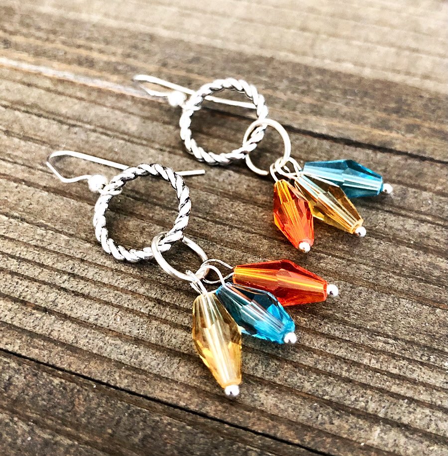 Aura Eternity Earrings by Rayvenwoodmanor. These silver eternity circle earrings are accented with mystic blue, golden yellow and orange color change crystals. A fringe, hippie style earring for every day wear. In our Etsy shop! 
Rayvenwoodmanor.Etsy.com 
#circleearrings #fringe