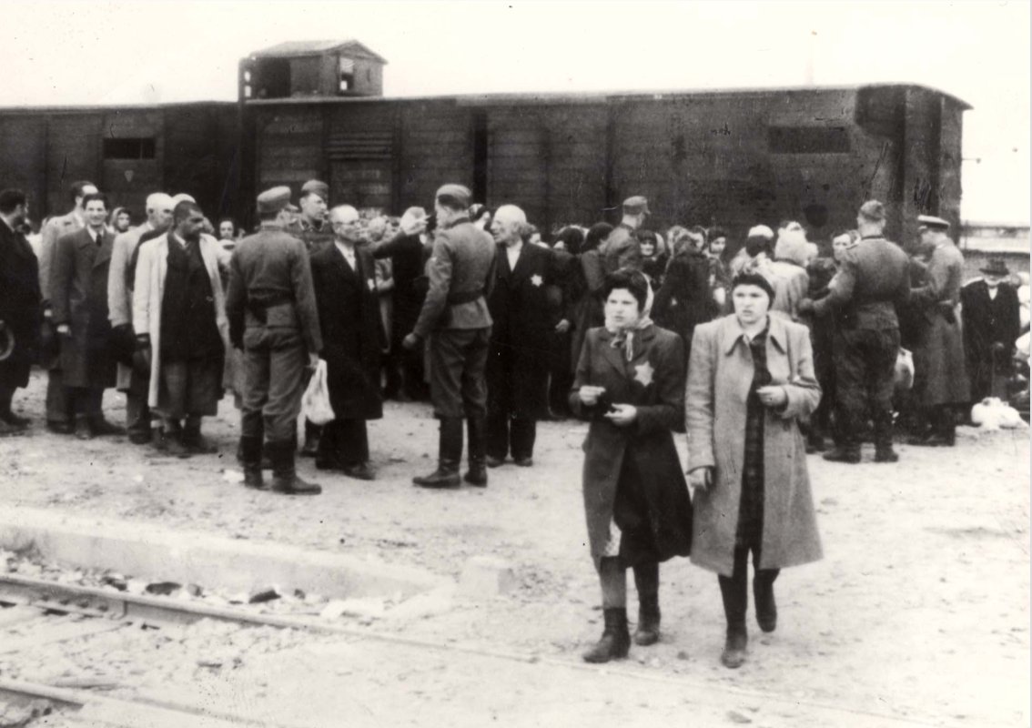 May 27, 1944 | After their arrival to Auschwitz II-Birkenau, two Hungarian Jewish young women at the front of the photograph are selected for forced labor from the selection on the platform.