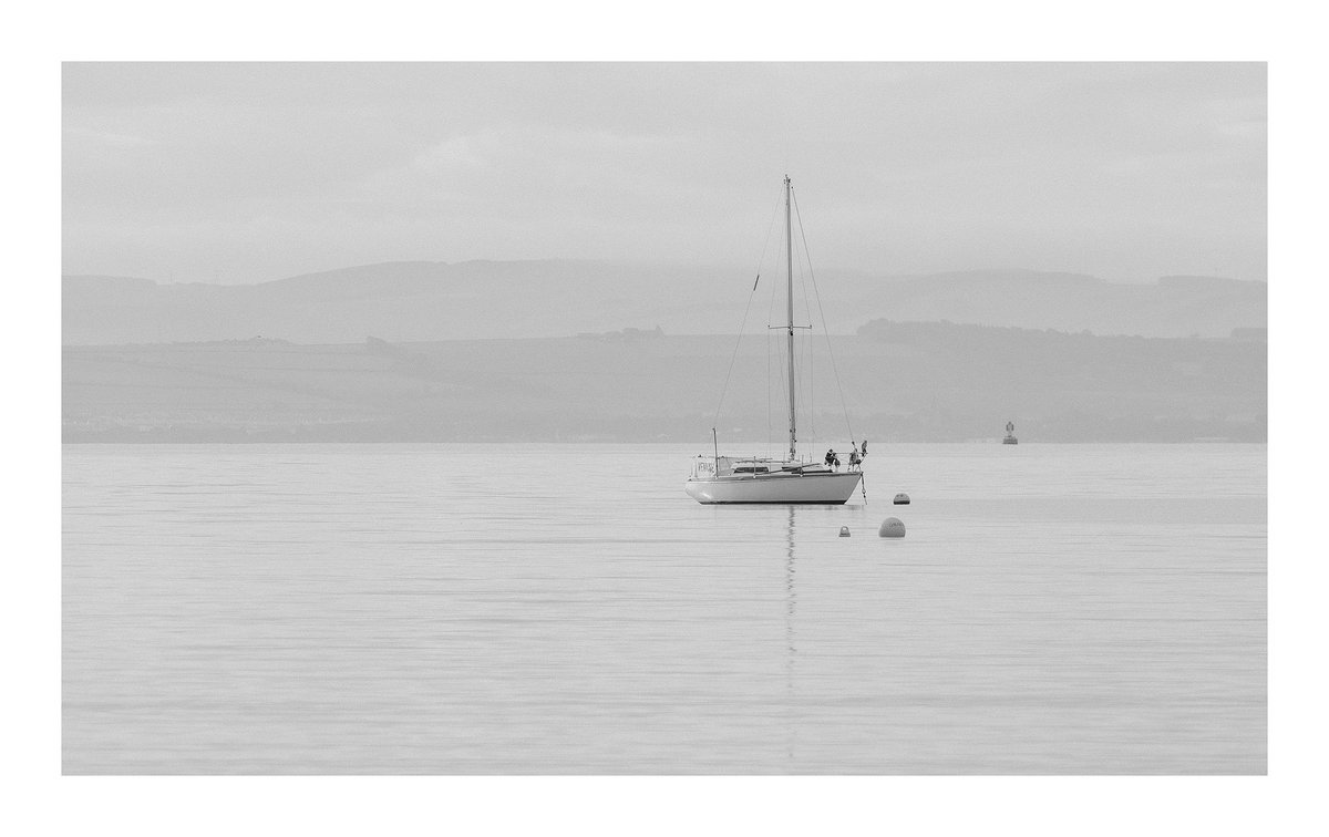A serene sailboat glides through the tranquil waters, with the misty hills of Fife, Scotland, #Scotland #Fife #wexmondays #sharemondays2024 #fsprintmonday