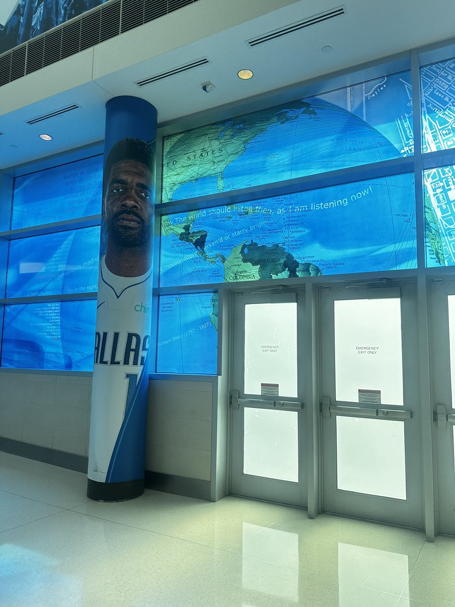 theo_mackie's tweet image. Dallas airport has a Kyrie poster next to a picture of a globe, amazing work by someone in the art department