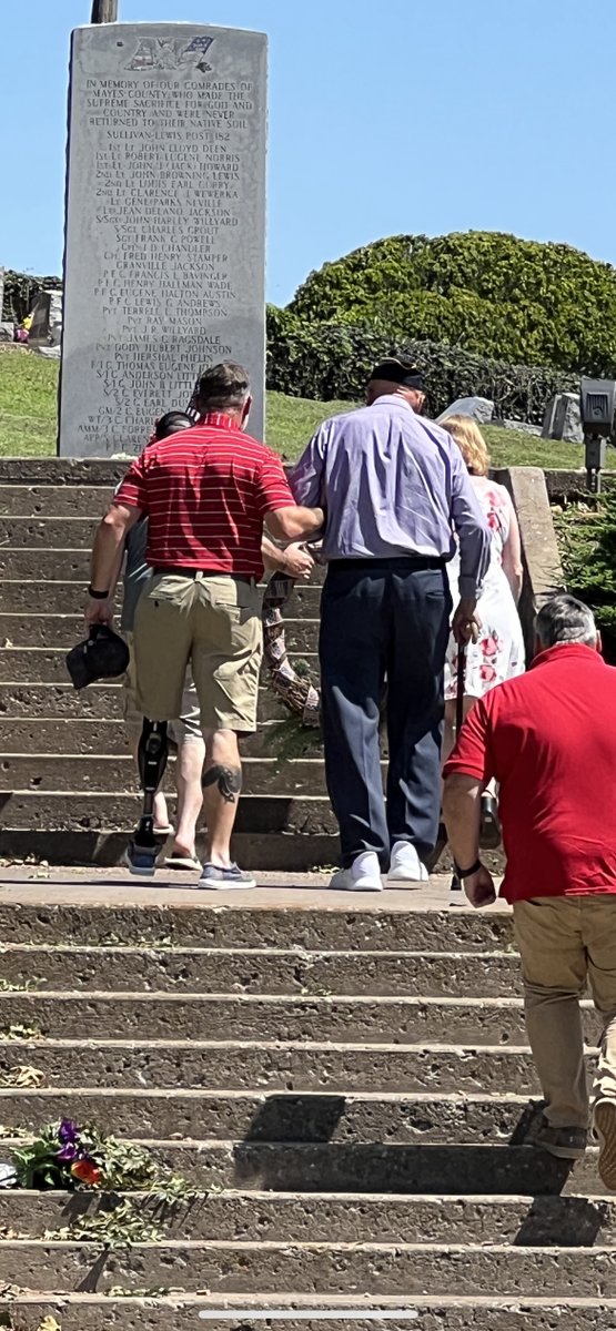 That is a Marine who lost his leg in Ramadi on the left helping a WWII Veteran up the stairs to the lay a wreath on the memorial.