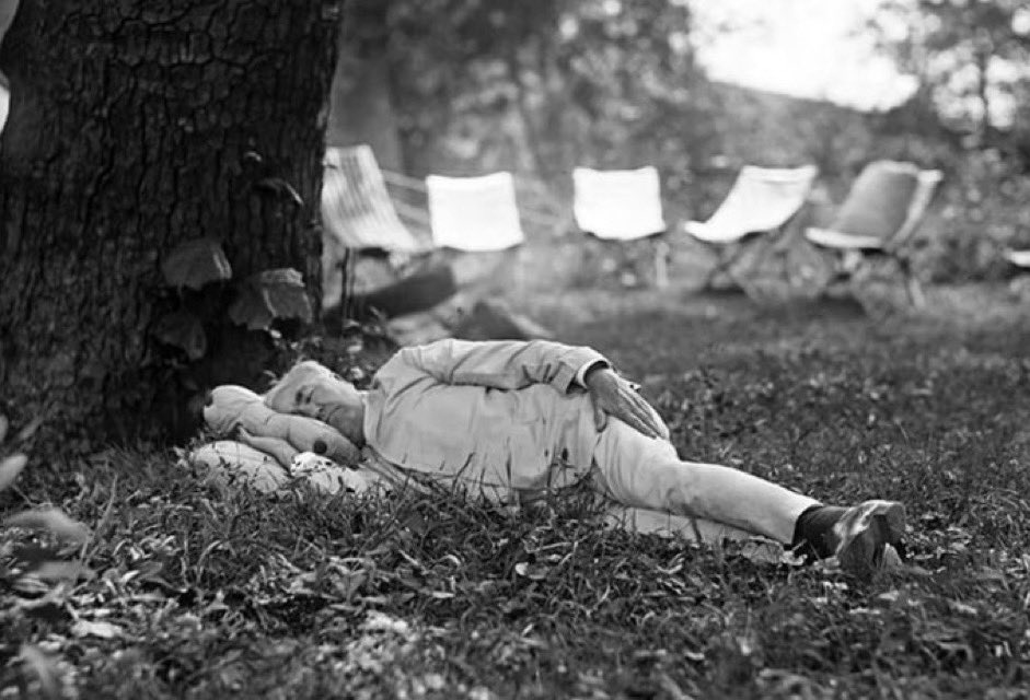 American inventor and businessman Thomas Edison enjoys a mid-day nap under a tree while camping with Henry Ford, President Warren Harding, and Harvey Firestone. Washington County, Maryland, USA. July 1921.