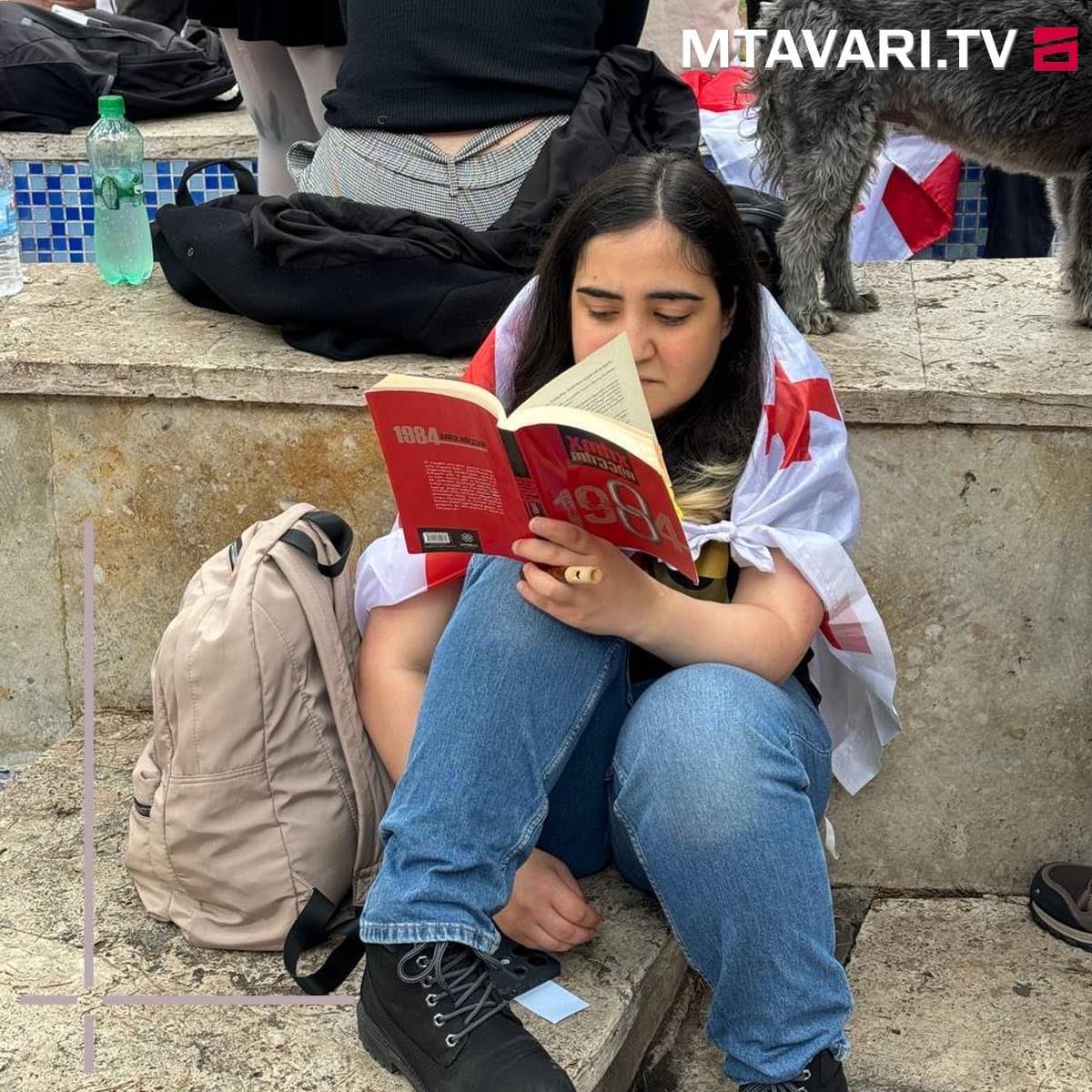 A protester is reading Orwell’s 1984 at a rally against the Russian foreign agents law outside the Parliament of Georgia 🇬🇪