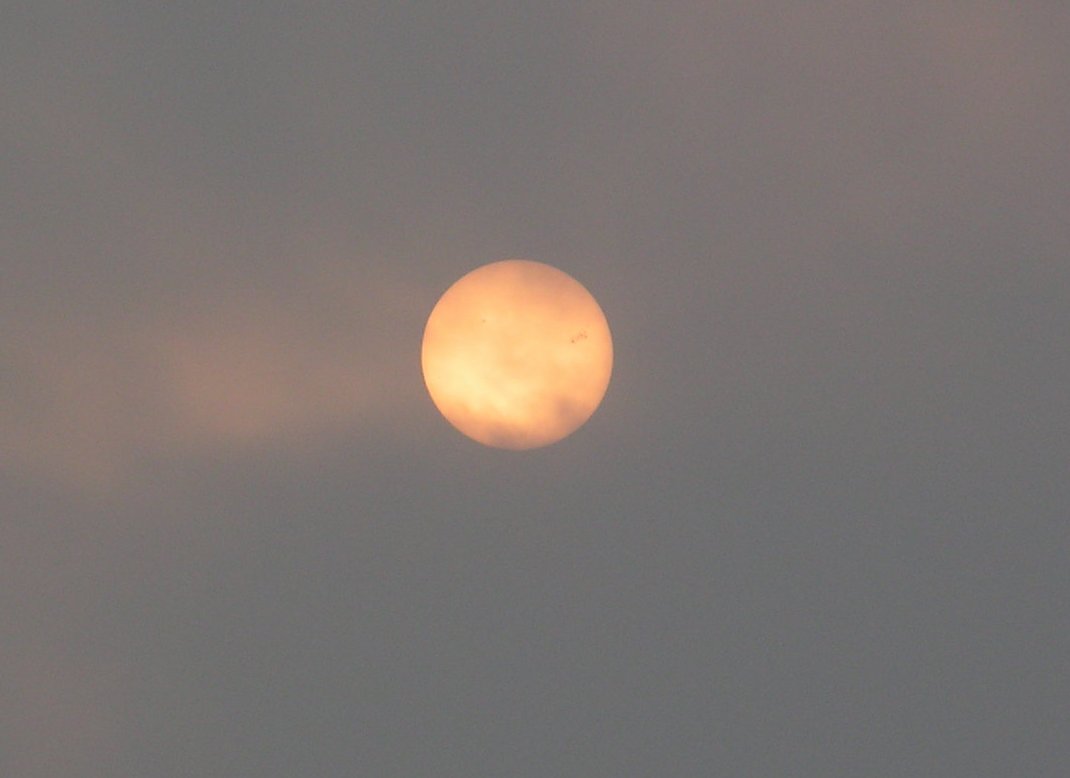 I was looking closely at one of the photos I took of the sun through the clouds, and you can clearly see a few sunspots on the surface!