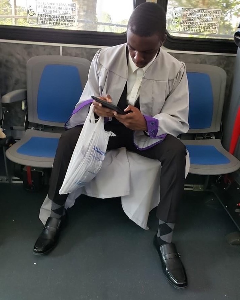 Viral photo of a young man spotted  going to his graduation alone on the bus with his cap inside a walmart bag.