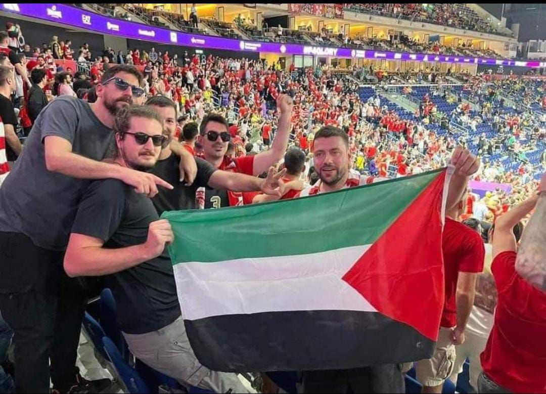 Los aficionados del equipo griego Olympiacos izan la bandera palestina durante un partido de la Liga Europea de Baloncesto.