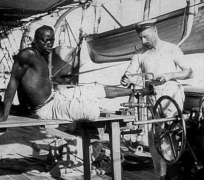 In 1907, a British sailor is seen unshackling an enslaved man who had been chained for three years. The photo was taken by Joseph Chidwick, a crew member of the HMS Sphinx. The man in the photos had managed to escape a slave-trading outpost off Oman's coast upon