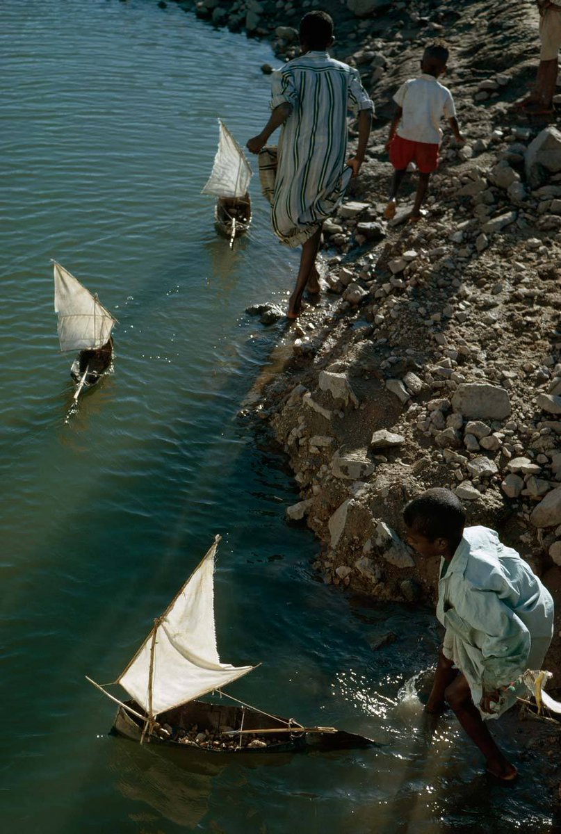 Boys play with toy sailboats along the Nile south of Aswan, Egypt, October 1963.

📷: National Geographic