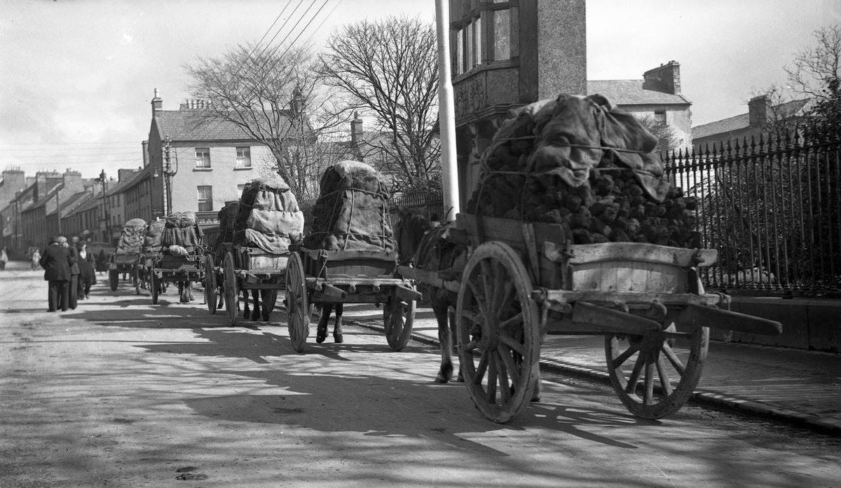 Great weather for the bog.
Image shows cartloads of turf for sale in front of the Browne Doorway, Eyre Square in the 1950s. 
>Fáilte Ireland Tourism Photographic Collection. Courtesy of Dublin City Library & Archive.
