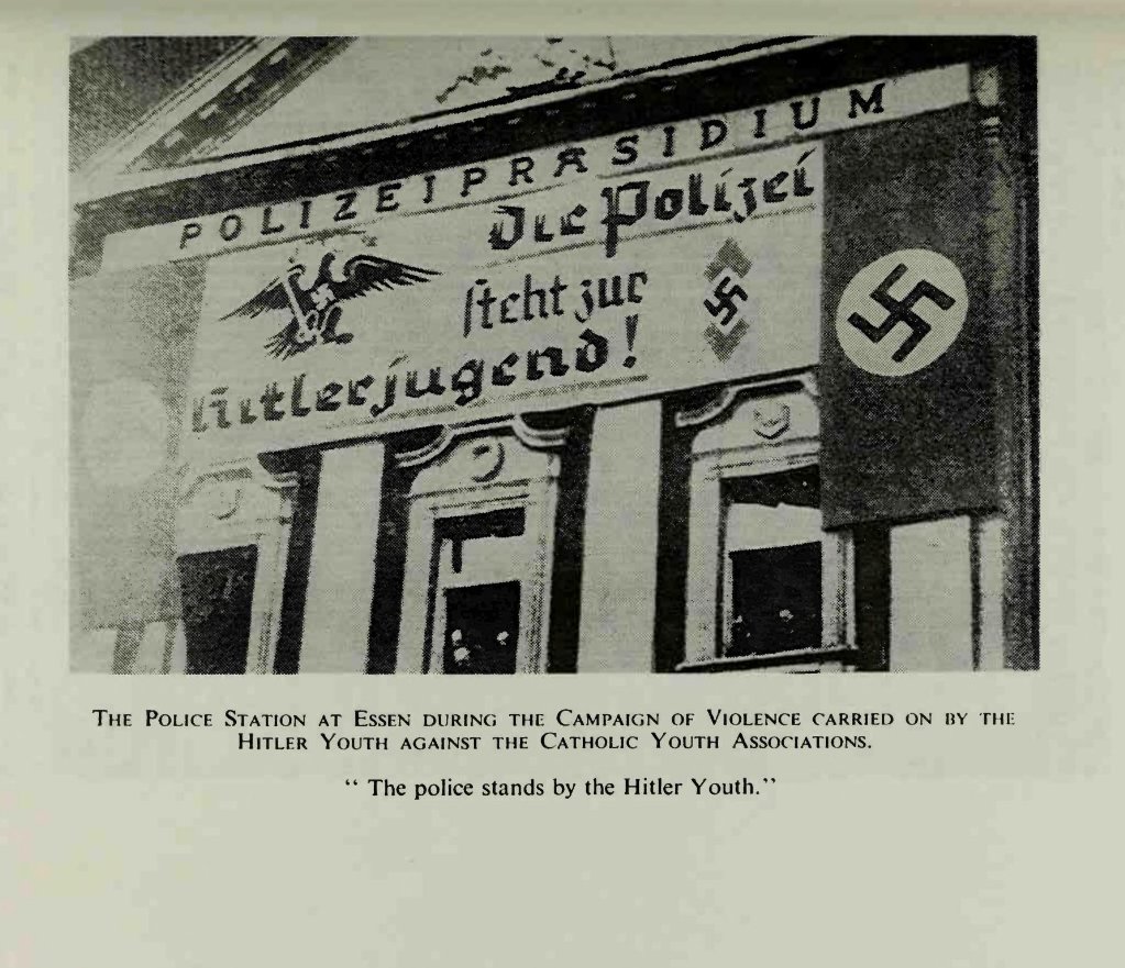 Police station in Essen during the campaign of desecration carried on by the Hitler Youth against Catholic Youth Organizations. 

'The police stands by the Hitlerjugend!'