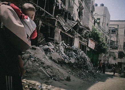 People walking beside destroyed buildings, while bodies are still under the rubbles of it in Nussairat Camp. 

May 2024.