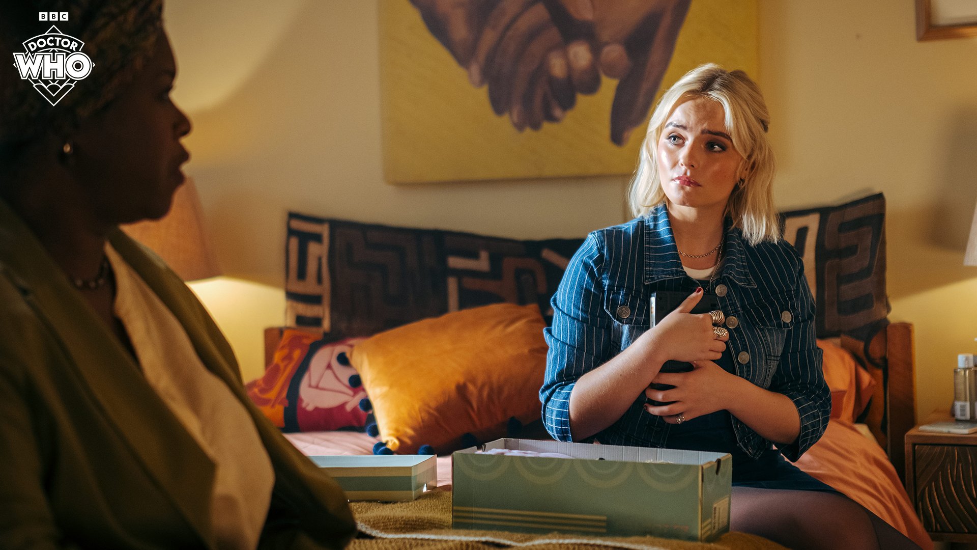 Ruby (Millie Gibson) holds an object to her chest as she speaks to Carla (Michelle Greenidge) in 'The Legend of Ruby Sunday'.