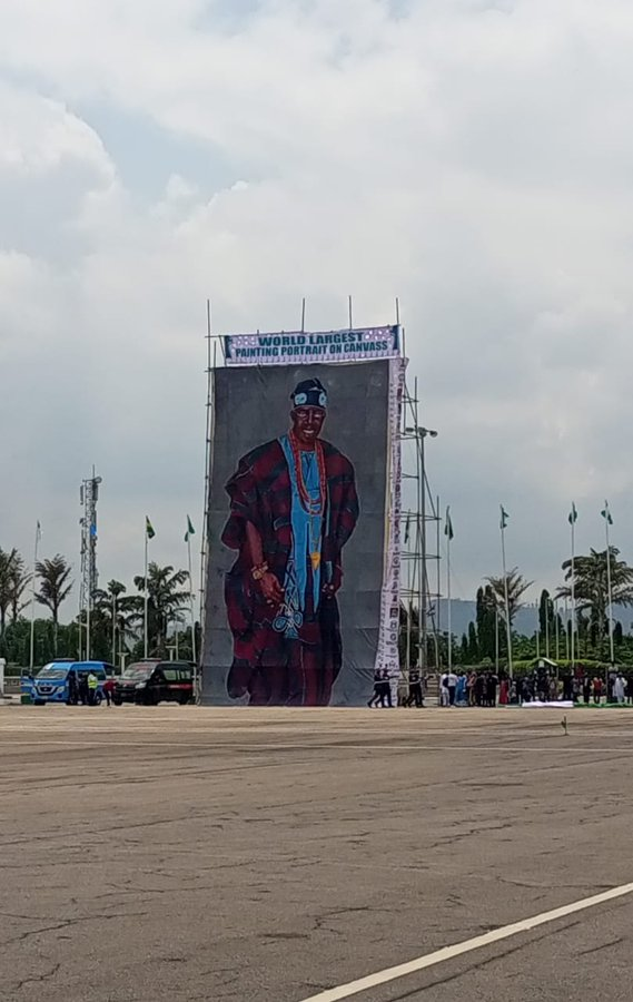 FinPlanKaluAja2's tweet photo. Where will this be displayed after today?

I suggest we create a Federal Commission of Canvas Portraits to maintain and manage this world record setting portrait.

If we display it in major cities and stadiums, i think tourist will travel to Nigeria to see it, that will earn Nigeria FX to repay her Eurobond debt. 

Because of huge demand to view it, i think the location of the portrait should move from State to State according to Federal Character Principal. I want Abia to host it first. 

This is good thinking. so why cant we do more by printing a canvas portrait for the VP, Senate and House leadership? that way the tourist can see more and invest more

We can also threaten bandits, if they don't surrender and allow more food to come to the cities, we will not display this poster in their States. that will solve inflation as well

Lets think outside the box please