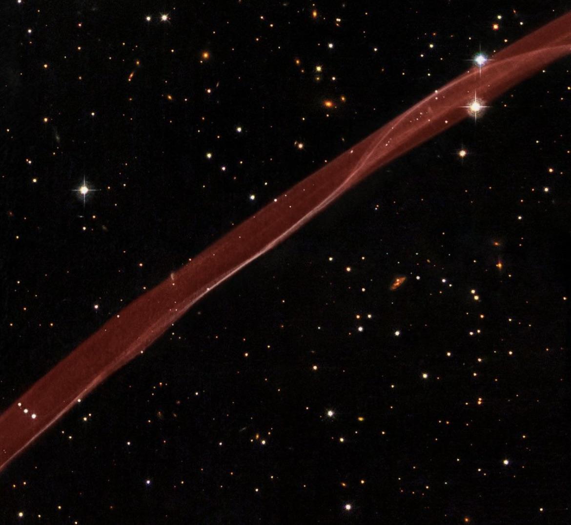 latestinspace's tweet photo. Red Ribbon-like remnant of a supernova crossing the cosmos captured by NASA Hubble https://t.co/6clnZsbD76