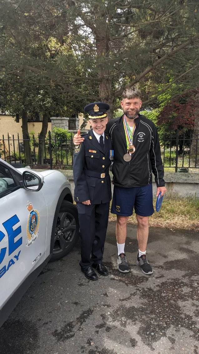 OakBayPolice's tweet photo. Chief Julie Chanin led the Oak Bay Tea Party Parade today. Thx Chris for riding along. Chris is a Vancouver Island Special Olympian who medaled in skiing & soccer. Thank you to our OBPD members and volunteers for a safe and successful parade. #SOBC #LETR #specialolympicsbc https://t.co/eQeHZJGrN2