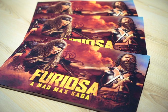 HIDEO_KOJIMA_EN's tweet photo. Saw Furiosa: A Mad Max Saga in IMAX for the third time. Bought 3 booklets. The chase scene with Octoboss (the name is like MGS). It still makes me roar no matter how many times I see it. The rhythm of the movement and the attacks backwards, forwards, under the truck, in the air and on the truck, the direction and the camera. The "glue space" between the action sequences is well defined, so it is easy to understand even when the positions are changed. This kind of connection cannot be achieved by shooting with multiple cameras simultaneously and then editing. It is a miracle that everything was calculated and studied in the pre-visualization and realized with stunts and VFX. This is action art. The way the chase is introduced is also well done. A sidecar driven by a black octopus crosses the road, where we get a glimpse of his skate shoes. After that, a moving camera from behind frames the chase in a single shot. The skate gimmick is revealed, the parachute opens, and the octopus emerges. The parachute octopus on the other side of the track also appears, and the camera rises with it, spinning above the track (and replacing the parachute), leading to the attack and defense with the Warboys. Only George could have done such a complex one-shot. Sigh. I'm going to see it again, not in IMAX, but in CinemaScope, and then the Japanese dubbed version.