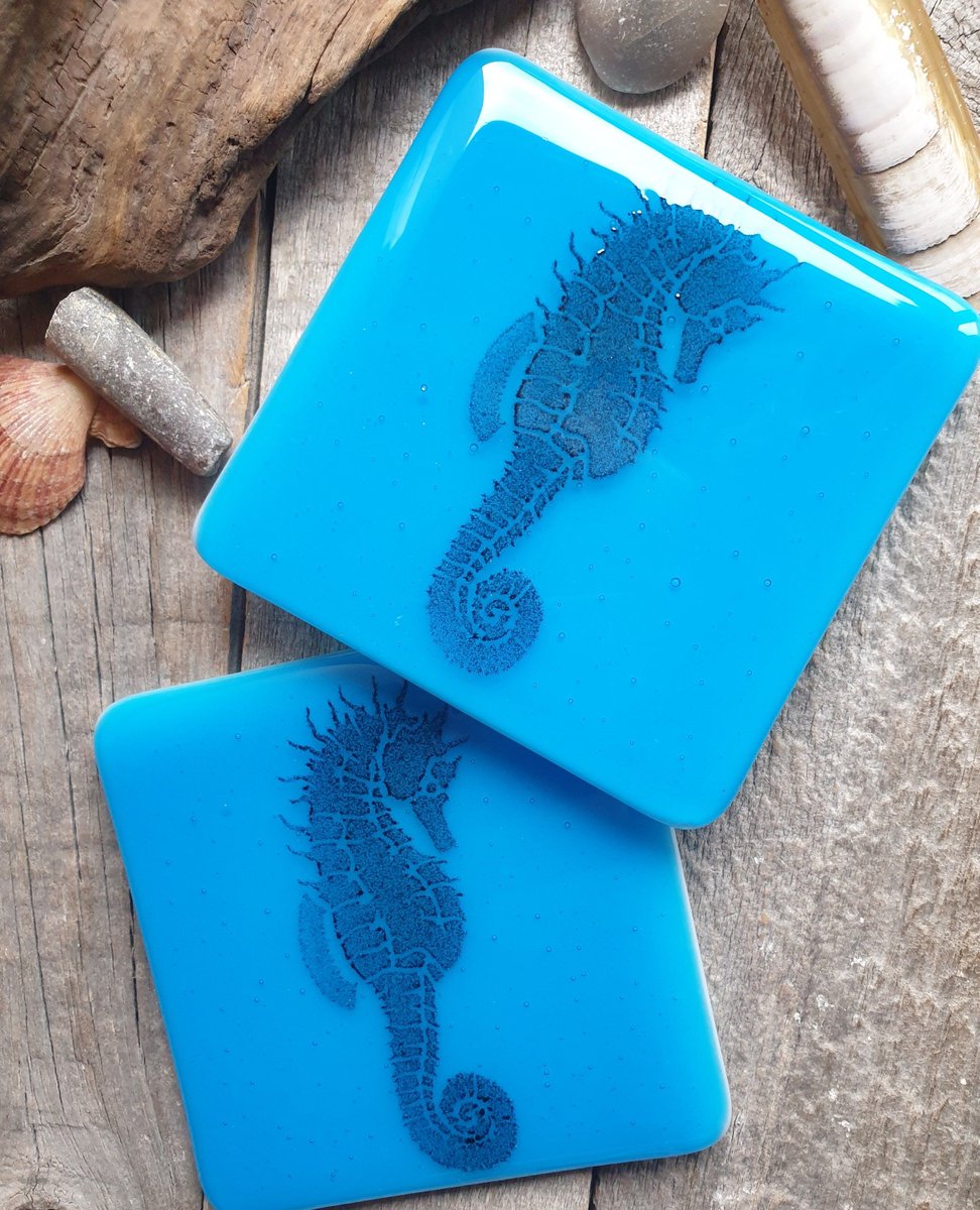 Amazing handcrafted seahorse coasters. Made from turquoise blue glass and clear glass. Fused together in the kiln, then a black glass powder seahorse design is applied to the surface and fired once again. #handmade #giftideas #shopindie #etsy buff.ly/3wczk7Y