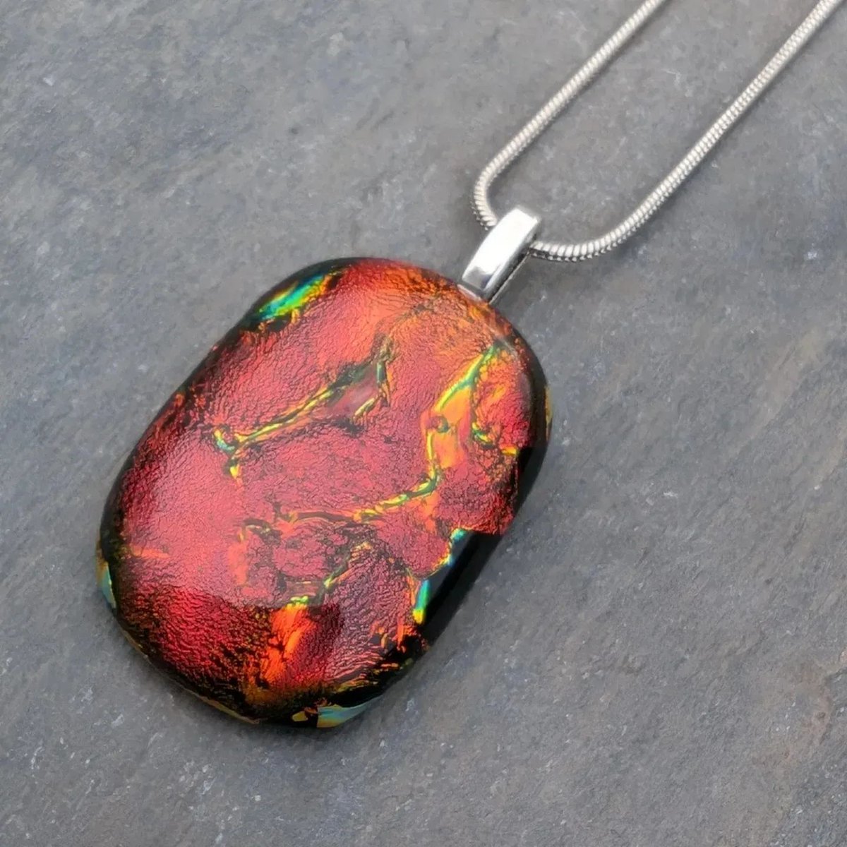 Amazing lava inspired dichroic glass necklace, stunning sparkling reds and golds within this unique pendant. #handmade #etsy #giftideas #shopindie #nature buff.ly/3VkvG66