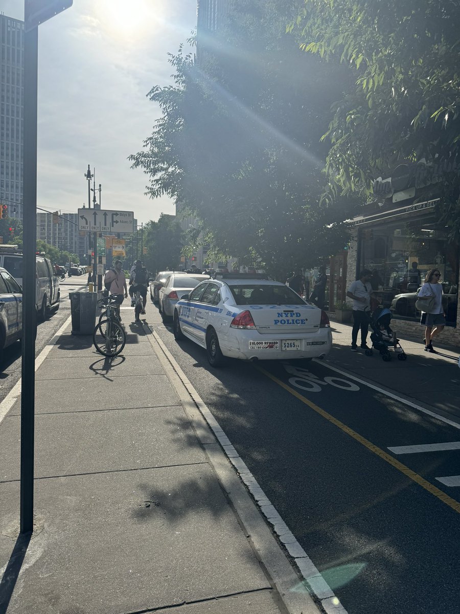 __anned's tweet photo. Cops “protecting and serving”—if protecting = sitting next to their cars chatting and serving = playing candy crush. @LincolnRestler this is a pretty common occurrence near the entrance to the bk bridge. @StreetsblogNYC @NYC_DOT @NYCBikeLanes https://t.co/juiVB0YRJz