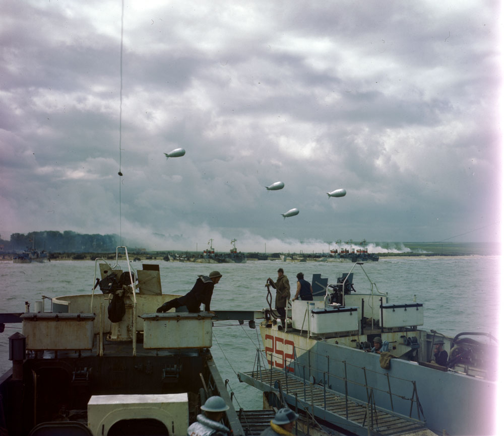 Canadian photographers &amp; cameramen like Ken Bell, Bill Grant and Gilbert Milne did outstanding work on D-Day  Less well-known are some vivid colour shots like this one of followup wave landing on the still-smoking beach. Original at Library &amp; Archives Canada.