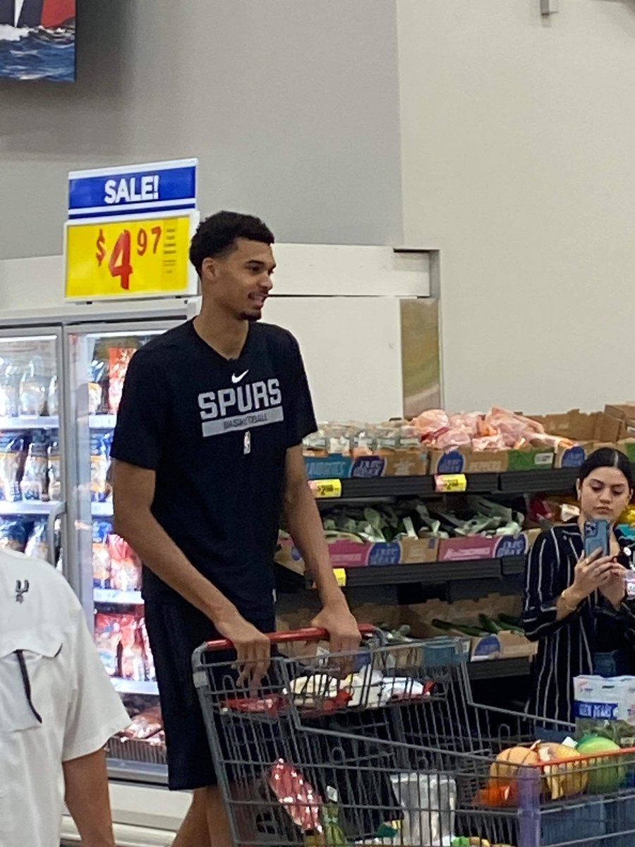 SpursReporter's tweet photo. When you’re not sure if that was really Victor Wenbanyama you saw at the neighborhood H-E-B grocery store, clue in to his t-shirt and to the Charantais melon (typical French melon) in his basket. 😉 #PorVida https://t.co/WRrAHrgvtw