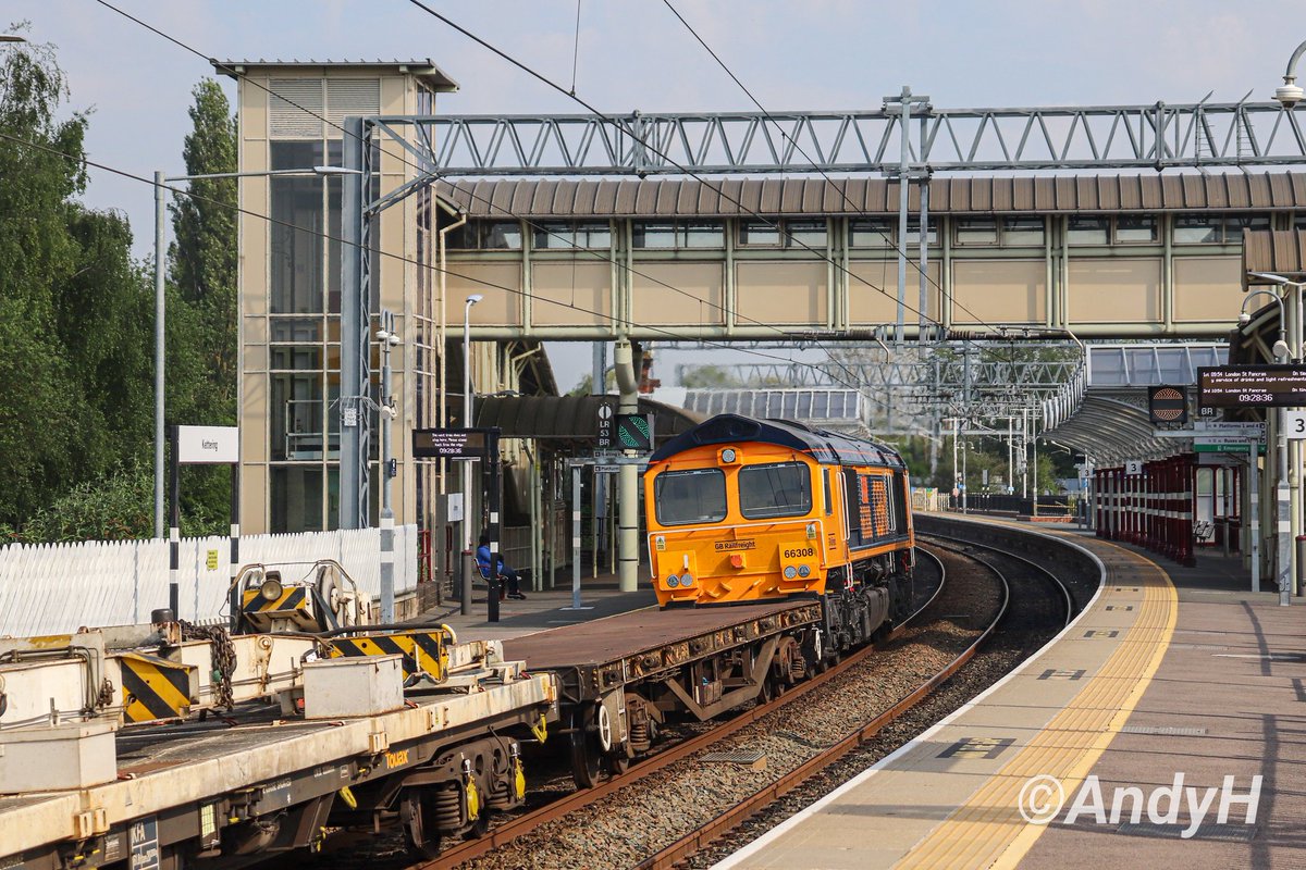 holtona72's tweet photo. #FootbridgeFriday from Kettering last month. Recent #GBRF Euro import 66308 'Signalman Willie Taylor' passes under the aforementioned structure with 6X36 bound for Toton. Quite an architectural contrast here between the modern bridge & Victorian canopies. #MML #ShedWatch 12/5/24 https://t.co/jLOi6kD5uP