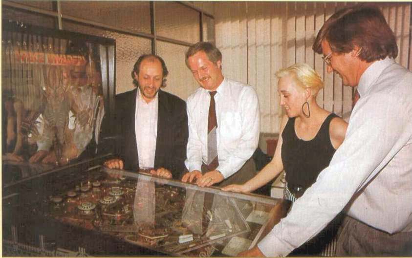 Mastertronic's Martin Alper, John Maxwell, Alison Beasley and Alan Sharam have fun on the office pinball machine circa 1985.