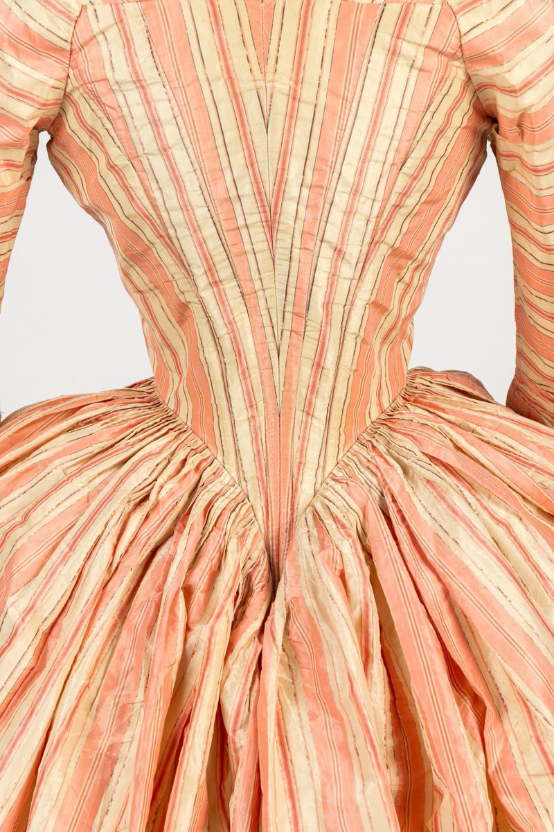 kateStrasdin's tweet photo. Patterns matched, pleats tweaked into place to fashion this pink striped #1770s gown, every single stitch worked by hand. The fabric has been changed this way and that to run in different directions for different effects culminating in the deep V at the back @Fashion_Museum https://t.co/ehqSDVnQKF