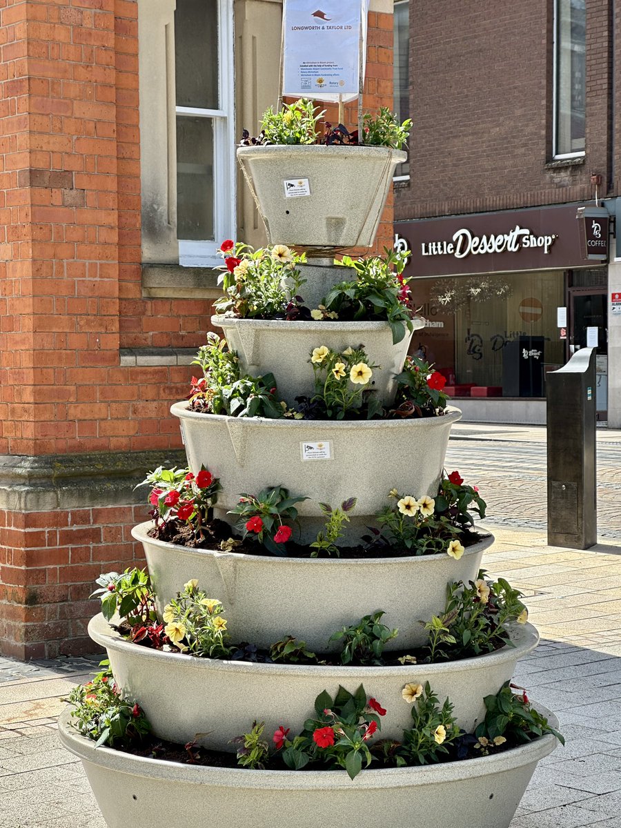 Windy today 💨 so much compost was eaten (pah!) while we were planting our ‘Ready, Steady, Go’ planting scheme in <a href="/amberolUK/">Amberol UK</a> beehive planters outside #Altrincham Interchange today. It’s a drought-resistant mix of hot reds, oranges, yellows and greens plus Jet Black Ipomoea ☀️🕶️