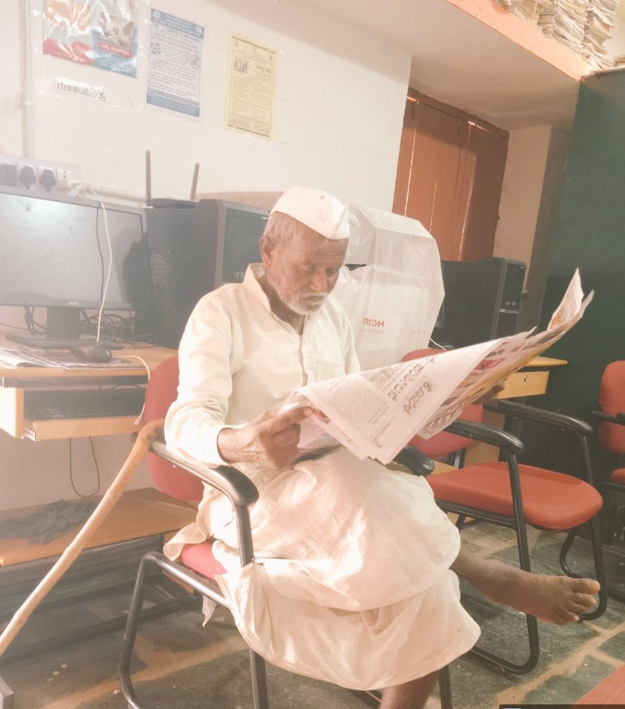 readingkafka's tweet photo. Elderly reader reading the newspaper in this rural public library in Koppal. Libraries are for everyone. #librariesforall https://t.co/MrzAeZ31sC