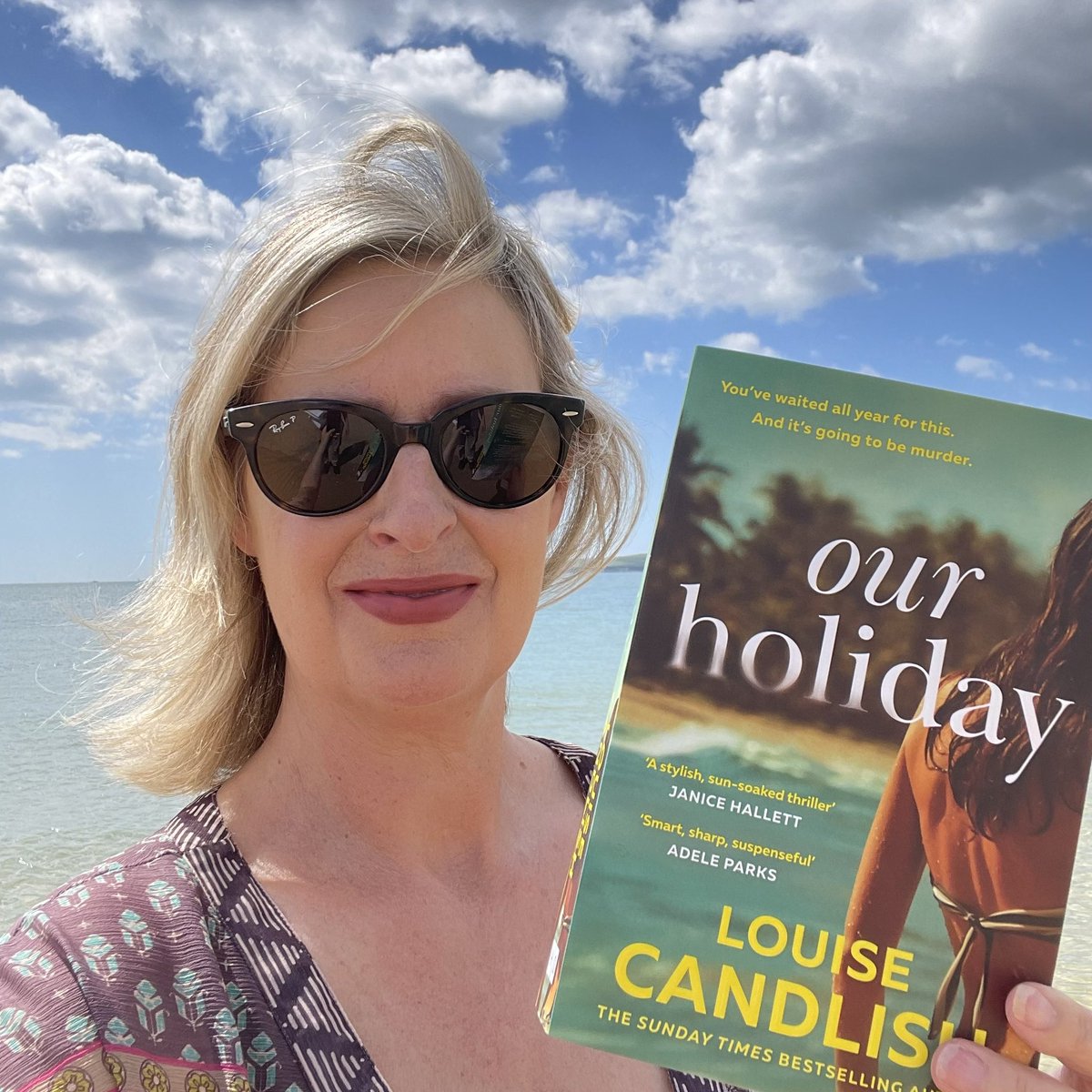 Behold this beautiful early copy of #OurHoliday right where it’s meant to be - on the beach! Out 4th July, pre-order link in bio ⛱️⛱️⛱️