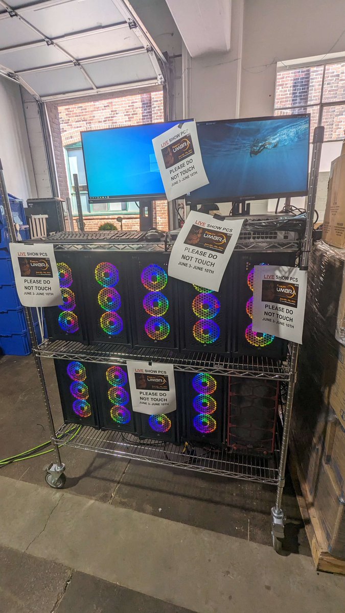 Photograph of the Furality Live Show PCs: a whole rack of big, RGB PCs at work to make Furality events happen. Sheets of paper imploring to DO NOT TOUCH are stuck all about.