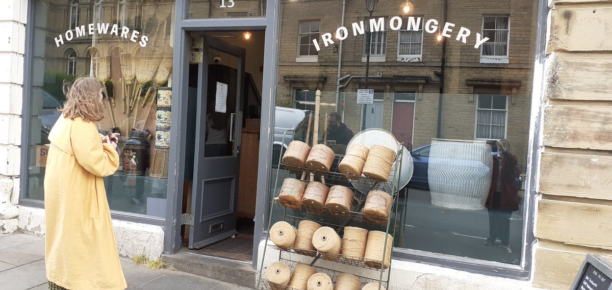 Saltaire is being transformed - back to the 1920s, for another film set. Here's my daughter, going into the 'Ironmongery', to buy a doughnut! #Bradford #Bradford2025 #BradfordCityofFilm #Saltaire
