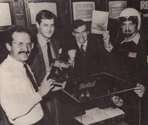 LegendsSpectrum's tweet photo. Domark's Dominic Wheatley (second from the left) and Mark Strachan (second from the right) celebrate the release of its latest game, Eureka! The glass box holds £25,000, the prize for the first person to crack the game. It was won by 15-year old Matthew Woodley. https://t.co/G0RuM6KnBQ