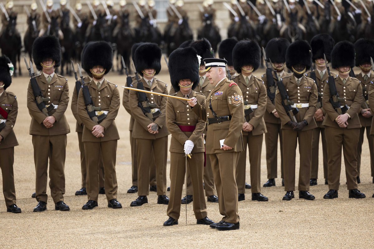 Garrison Sergeant Major Vern Stokes gives instructions with his pace stick to the Welsh Guards Captain of the large guard of honour on Horse Guards Parade during a Rehearsal for the Japanese State Visit. Behind them the Welsh Guards stand in neat rows at ease awaiting their next order of command.