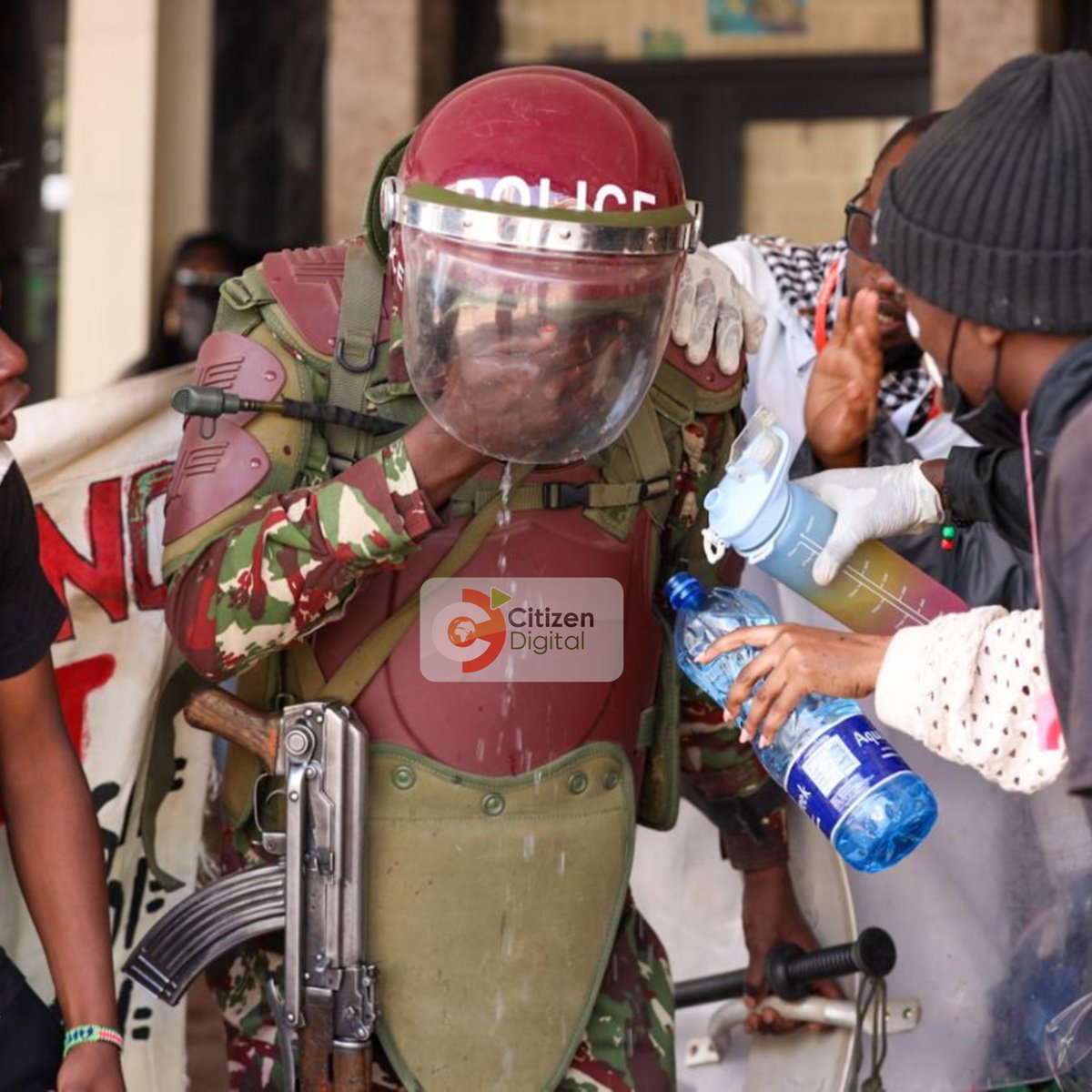 citizentvkenya's tweet image. Nairobi: Protesters assist a police officer during the Anti-Finance Bill demos