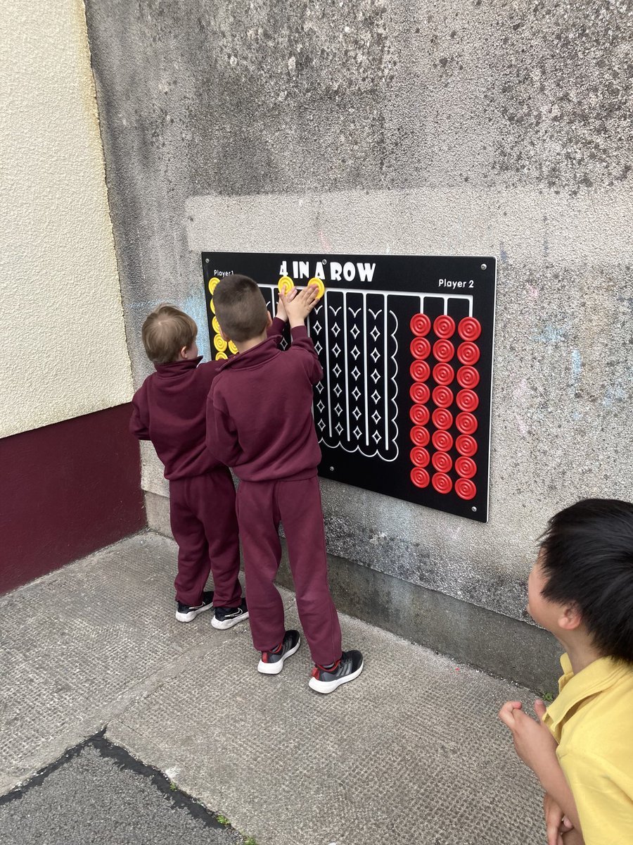 Infants enjoying the recently installed games in the playground.