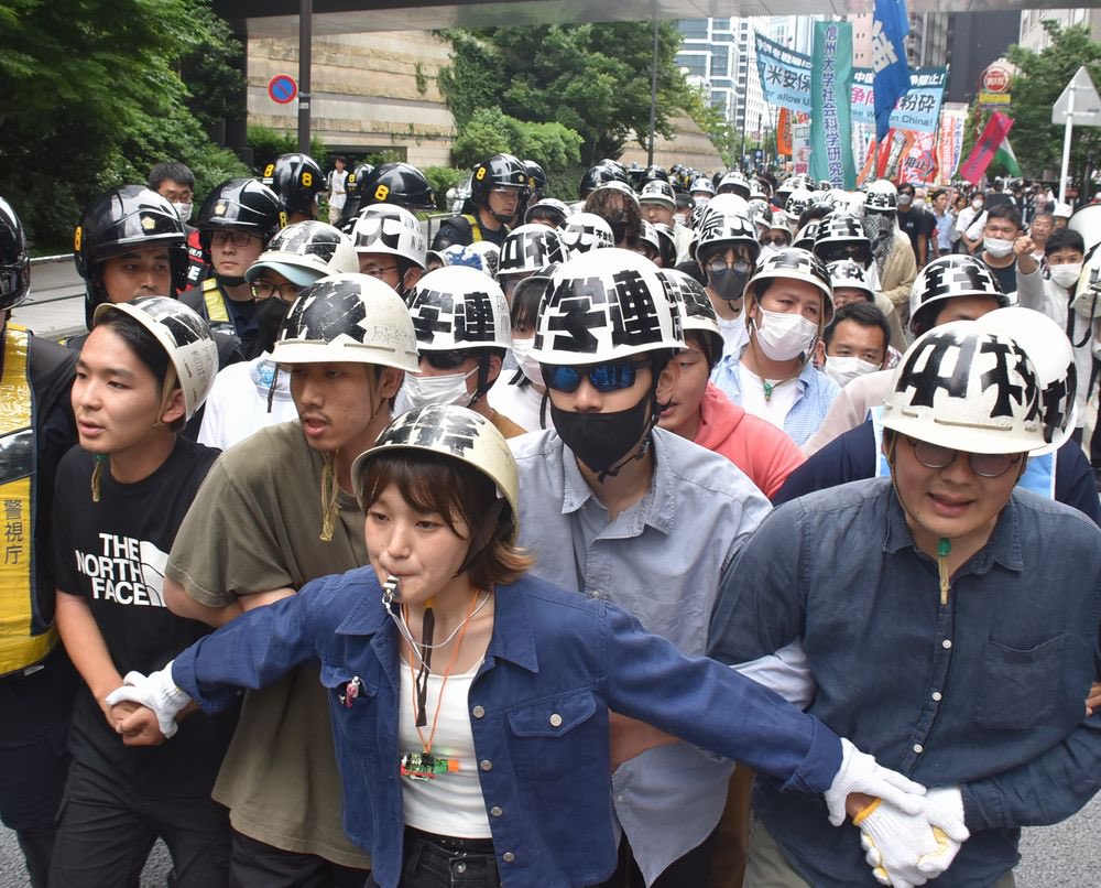 HoraguchiTomoko's tweet photo. 6月9日東京で1000人の反戦デモ。写真は機動隊の阻止線を前に、スクラムを組み米大使館に迫る全学連（@Zengakuren）と青年労働者。デモの指揮は矢嶋尋副委員長（@toshobin）。すべての青年・女性は戦争・差別・抑圧を生み出す資本主義社会を打ち倒す革命にともに立ち上がろう！
https://t.co/sgrBcCsNME https://t.co/kTmr8sl9uw