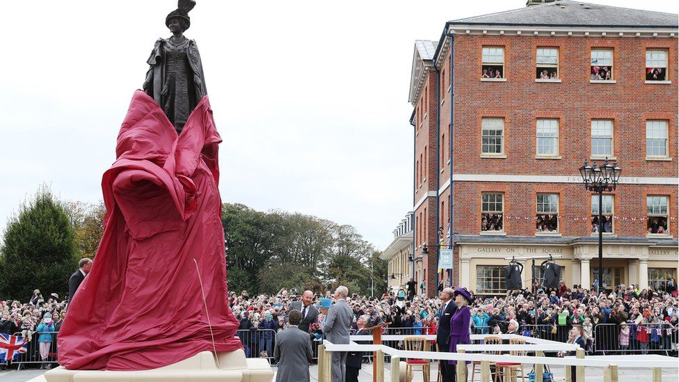 Obridge's tweet photo. Recently visited Prince--I mean KING--Charles's Poundbury. If you're unaware of the place's royal connections, then the massive sculpture of the Queen Mother is your clue! https://t.co/LpOYoIZbbw