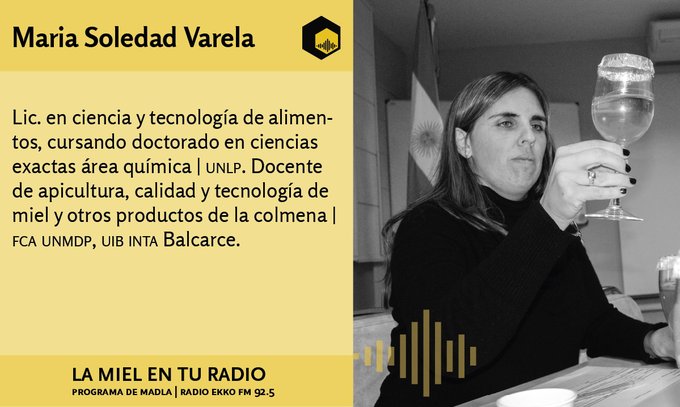 Se observa una mujer de cabello largo claro, desde la cintura hacia arriba. Está sentada, mientras mira fijamente la copa que sostiene con su mano derecha.