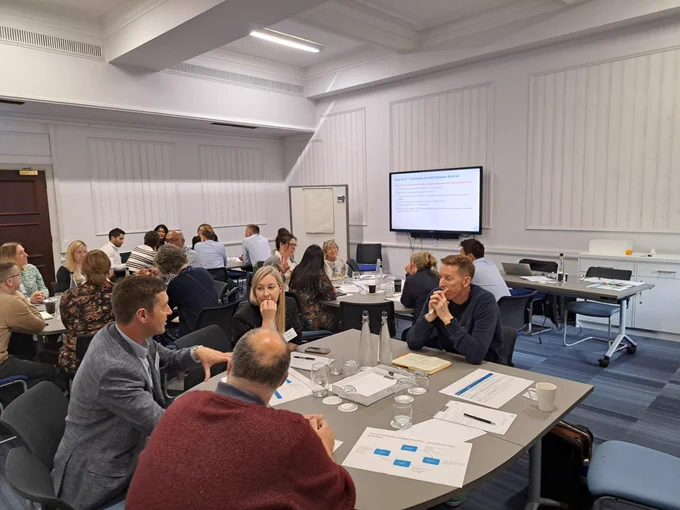 Group of 25 workshop participants discussing an exercise during our session in the BA Managers Forum.