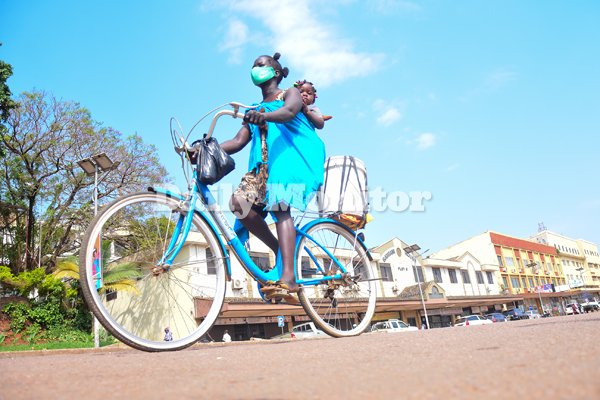 Let me leave this photo of a hustling lady who rides her bicycle with baby to look for customers to buy her gnuts during the lockdown