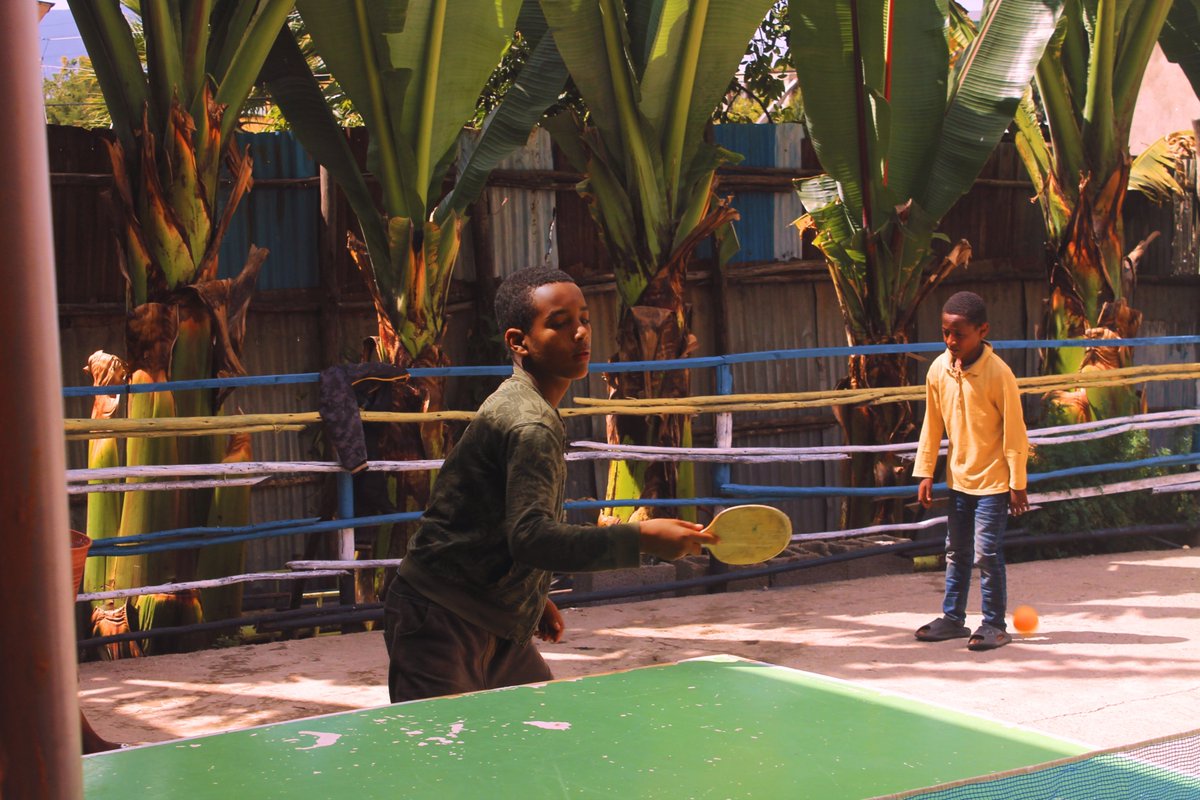 Table tennis is a popular game among the students at the community center. Yabsera is sharpening his hand-eye coordination in a fun match against his friends.
