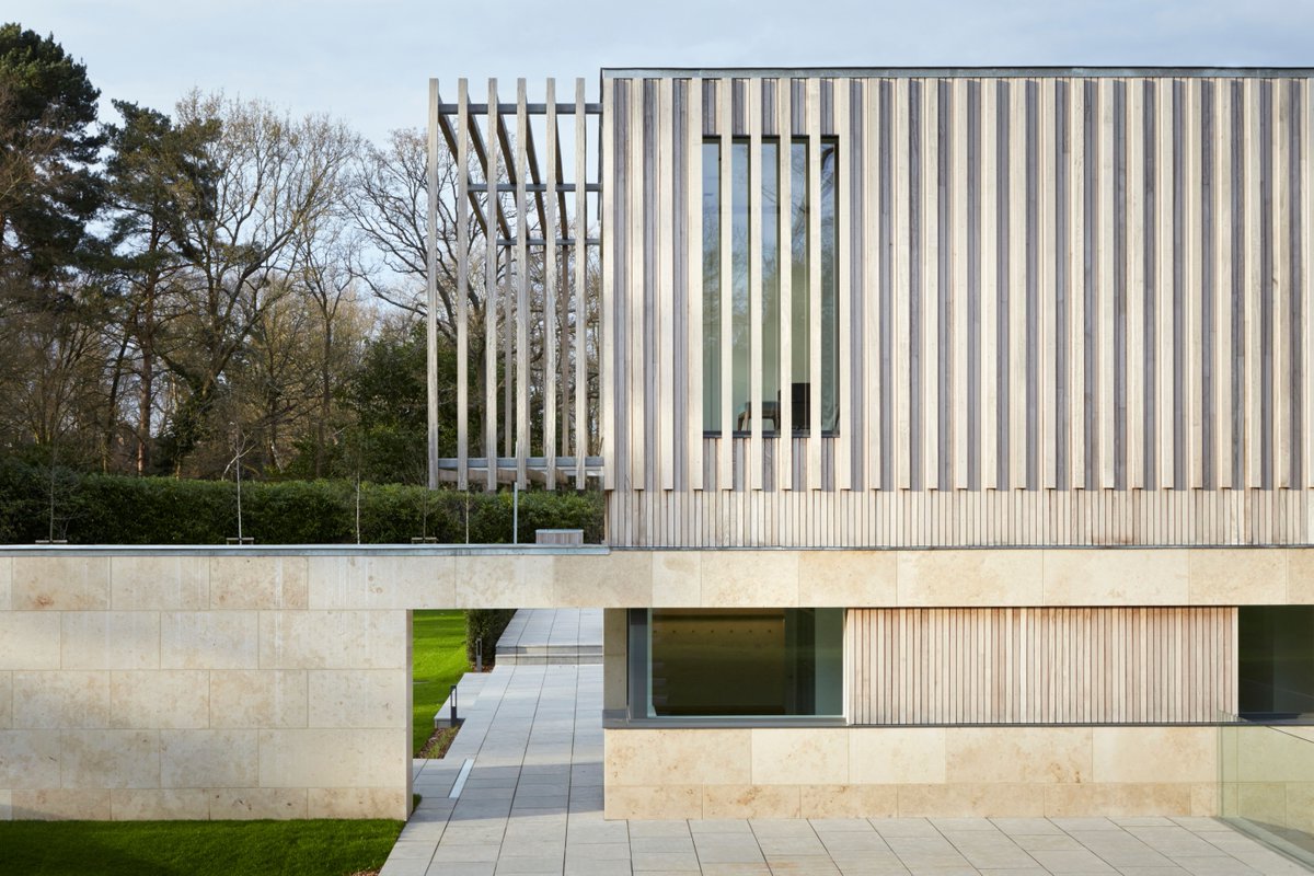 A combination of cladding and glazing in a muted palette, with natural stone panels, evoking a sense of grounding and solidity, while wooden accents introduce warmth and a tactile quality. #architecture #detail #cladding #natural #StoneArchitecture #RibaArchitects #quietLuxury