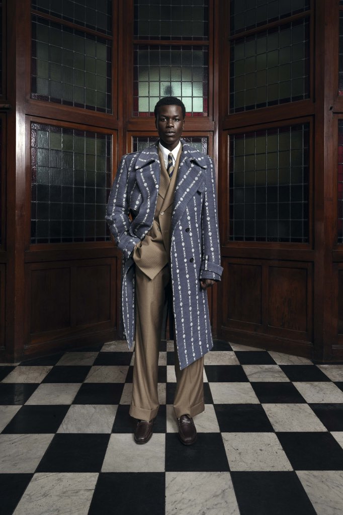 Michael wears our wool blend charcoal pinstripe

jacquard storm flap trench coat paired with our latte brown

double breasted classic fit tailored suit and our white

classic Egyptian cotton oxford shirt.