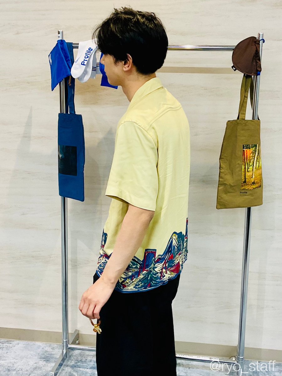 顔の見えない吉沢がつまんでいるのは #吉沢亮_写真展_2024 のグッズ